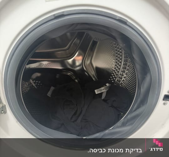 מכונת כביסה עם בגדים שחורים בתוף הפנימי